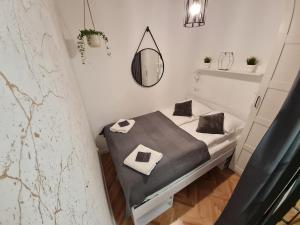 Habitación pequeña con cama y espejo. en Gdynia Główna Apartament, en Gdynia