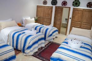 a group of three beds in a room at Ferme D'hôte Zomorroda in Marrakech