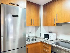 a kitchen with a stainless steel refrigerator and a microwave at Apartamento próximo a Plaza España 1 habitación Couto in Vigo +10 photos