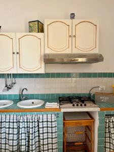 uma cozinha com 2 lavatórios, um fogão e armários em Montalbano House. Be our guest. em Sciacca