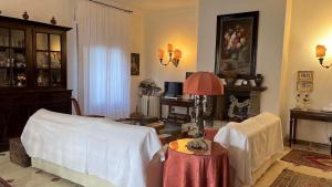 een woonkamer met een stoel en een tafel met een lamp bij CASA LUDOVICA TAORMINA with Sea View Terrace in Taormina