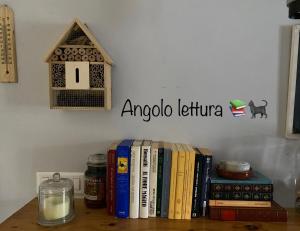 uma prateleira com livros e uma casa de pássaros e um cartaz em Nel cuore di Pescasseroli em Pescasseroli