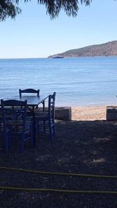 a table and chairs sitting next to the water at Kamares beach room 7 in Kamáres