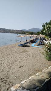 una playa con sombrillas, sillas y agua en Kamares beach room 7, en Kamáres