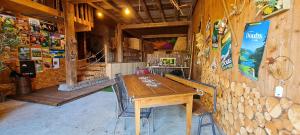 Maison d'hôtes et SPA La Boucotte في Vellerot-lès-Vercel: غرفة طعام مع طاولة خشبية وجدار حجري