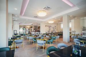 ein Restaurant mit Tischen und Stühlen in einem Raum in der Unterkunft Wellness Spa Hotel Jola in Banja Luka