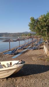 a row of boats on a beach with umbrellas at Kamares beach room 7 in Kamáres