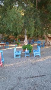 un grupo de sillas y mesas azules en un parque en Kamares beach room 7, en Kamáres