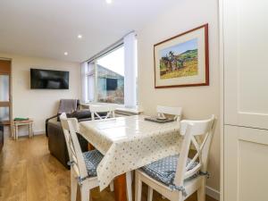 una sala da pranzo e un soggiorno con tavolo e sedie. di Steading Cottage a Kirriemuir