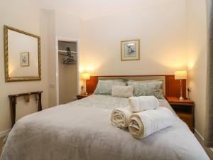 a bedroom with a large bed with towels on it at Steading Cottage in Kirriemuir