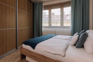 - une chambre avec un grand lit et une fenêtre dans l'établissement REVON Art-deco Apartment Laurinska, à Bratislava
