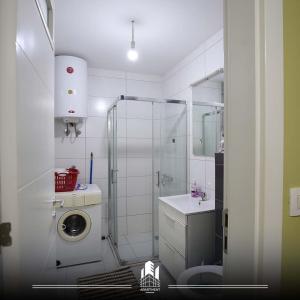 uma casa de banho com um chuveiro, um WC e um lavatório. em Prishtina Rent Apartment B Street em Pristina