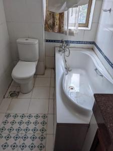 a bathroom with a toilet and a bath tub at Metro Hotel in Nairobi