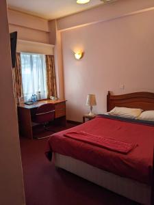 a bedroom with a bed and a desk and a window at Metro Hotel in Nairobi