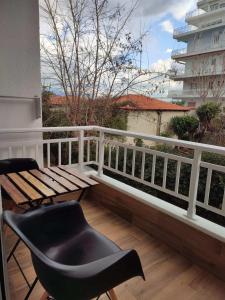 a balcony with a wooden bench and a table at Deluxe Apartment in Korinthos