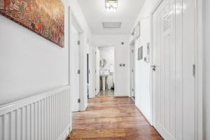 um corredor de uma casa com paredes brancas e pisos de madeira em Rusholme Rooms em Manchester