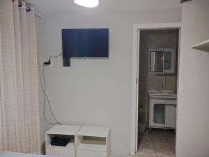 a living room with a tv on the wall at Apto Rua da Praia in Florianópolis