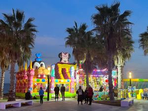 people walking in front of a carnival at night at Sol de mar, La Mata (Hiszpania) in La Mata