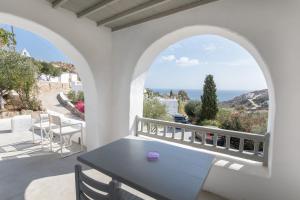 a table on a balcony with a view of the ocean at Apostolis Windmill in Psarou