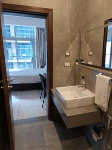 La salle de bains est pourvue d'un lavabo, d'un lit et d'un miroir. dans l'établissement Skynest Residences by Lisa's Paradise C, à Nairobi