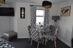 ein Esszimmer mit einem Tisch, Stühlen und einem Fenster in der Unterkunft Spacious 1 Bedroom Apartment In Wigan in Shevington
