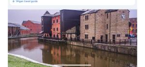 a group of buildings next to a river at Spacious 1 Bedroom Apartment In Wigan in Shevington