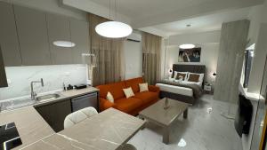 a living room with an orange couch and a bed at breath studio in Giannitsa