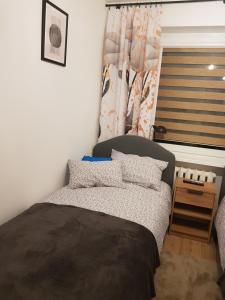 a small bedroom with a bed and a window at Apartament Chrobry in Kętrzyn