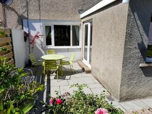 eine Terrasse mit einem Tisch, Stühlen und Blumen in der Unterkunft 2 Bed in Cockermouth 82631 in Cockermouth