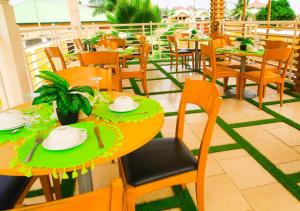 a restaurant with tables and chairs on a balcony at HILLS HAVEN HOTEL in Accra