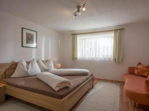 Un dormitorio con una cama con almohadas blancas y una ventana en Gästehaus Schwaiger - Lendgasse, en Kössen