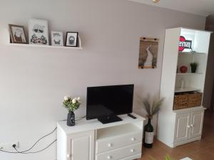 a living room with a tv on a white dresser at karluchi a Mariña 2 Barreiros in Barreiros