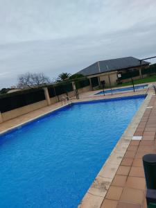 a large blue swimming pool with a building in the background at karluchi a Mariña 2 Barreiros in Barreiros