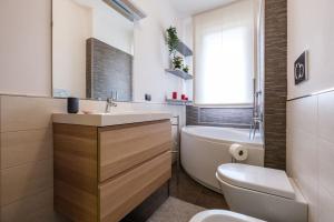 a bathroom with a sink and a tub and a toilet at Lussuoso e accogliente appartamento con terrazza in San Donato Milanese