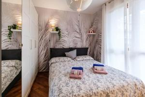a bedroom with a bed with two flip flops on it at Lussuoso e accogliente appartamento con terrazza in San Donato Milanese