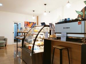 a bakery with a counter and stools in a store at Pinpoint Hotel Phuket in Ban Pak Lak