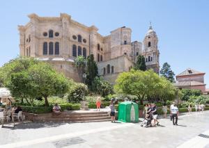 un grupo de personas de pie en frente de un edificio en Cathedral Suites, en Málaga