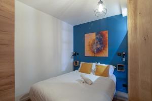 ein Schlafzimmer mit einem weißen Bett und einer blauen Wand in der Unterkunft Charmant Appartement Antibes in Antibes