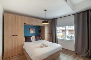 ein Schlafzimmer mit einem großen Bett und einem großen Fenster in der Unterkunft Charmant Appartement Antibes in Antibes