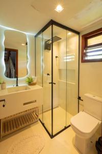 a bathroom with a glass shower and a toilet at Villa Meraki in Pipa
