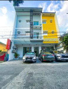 un gruppo di auto parcheggiate di fronte a un edificio di Luna Prime Hub And Inn a Olongapo