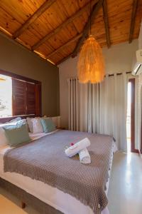 a bedroom with a bed with two towels on it at Villa Meraki in Pipa
