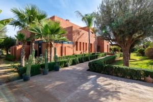 a house with palm trees and a walkway at Villa Dar Pampa Marrakech in Marrakesh