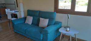 a blue couch in a living room with a table at La CASUCA ENTRE TINAS in Pesués