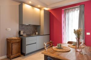 a kitchen with red walls and a wooden table at Regina Boutique Suites in Trieste +49 photos