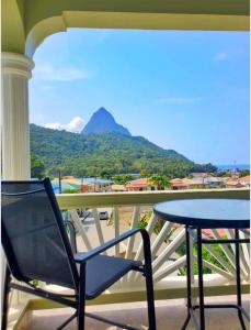 a chair and table on a balcony with a view of a mountain at La Pelle in Soufrière