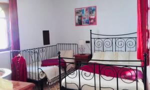 um quarto com uma cama de metal preto com lençóis vermelhos em Casa Azul em Chefchaouen
