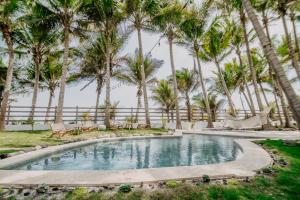 a pool in front of palm trees at Pacifica in Sipacate