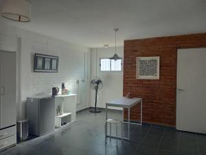 uma cozinha com uma mesa e uma parede de tijolos em Pedro_Simón em Puerto Madryn