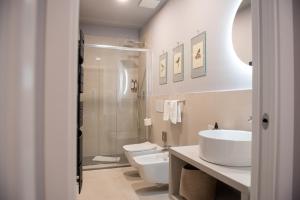 een badkamer met 2 toiletten, een wastafel en een douche bij CASA PEPE ROOMS & APARTMENTS in Trieste